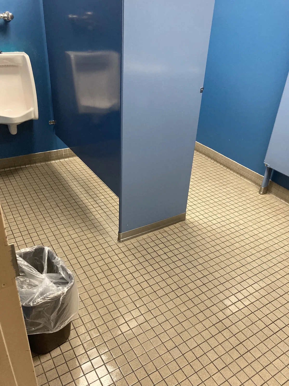 Commercial restroom with sinks, mirrors, stalls, and tile flooring