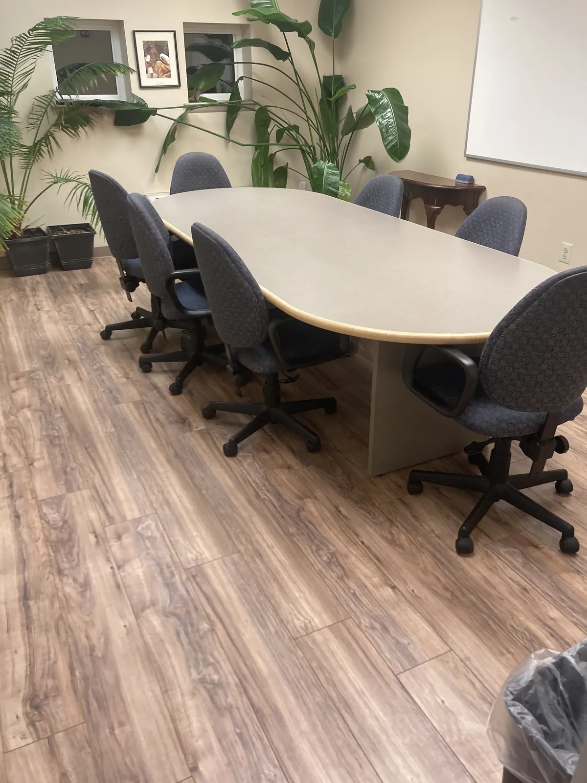 Office conference room with a long table and wood-look floor