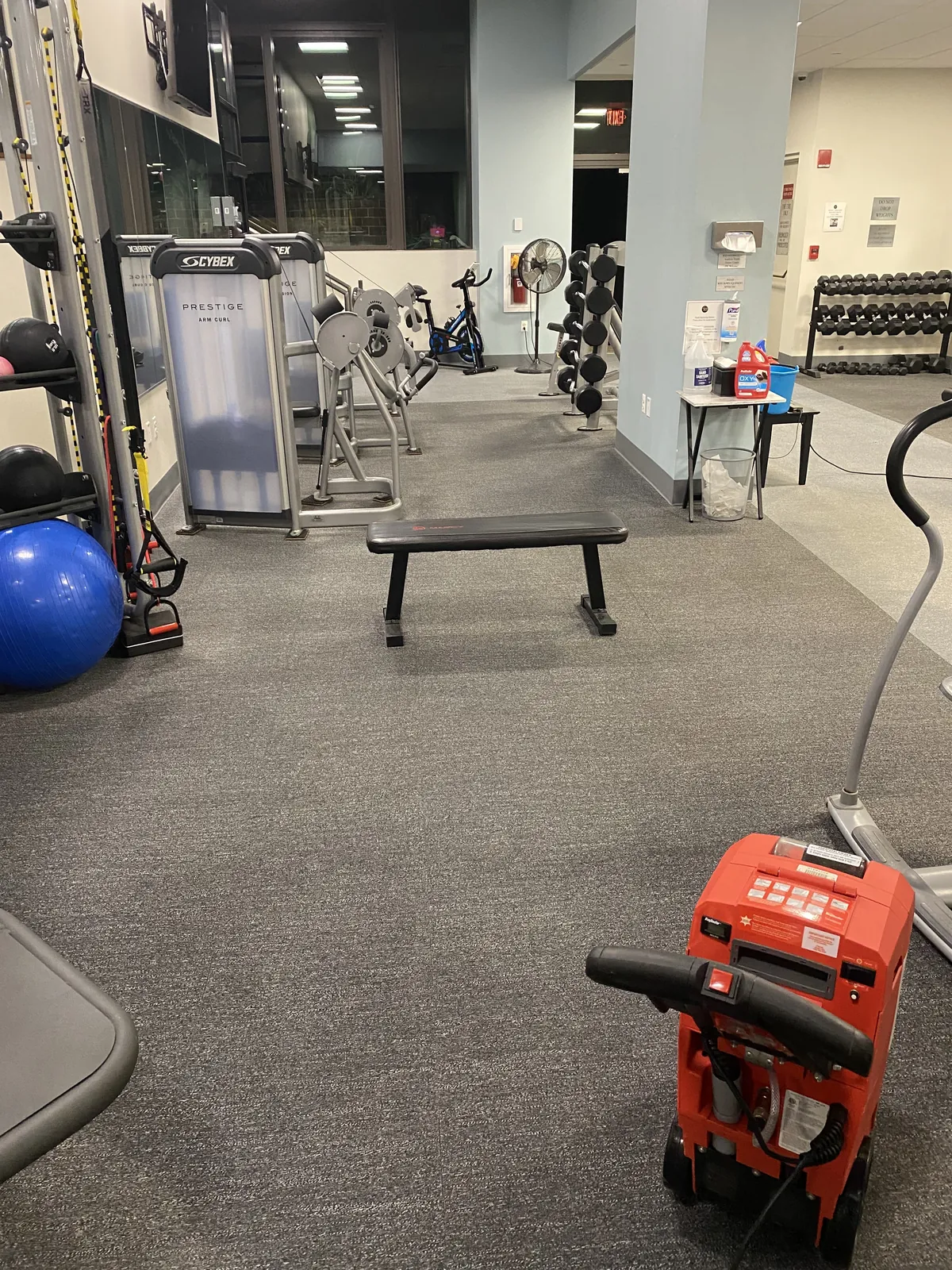Red carpet-cleaning equipment positioned in a gym