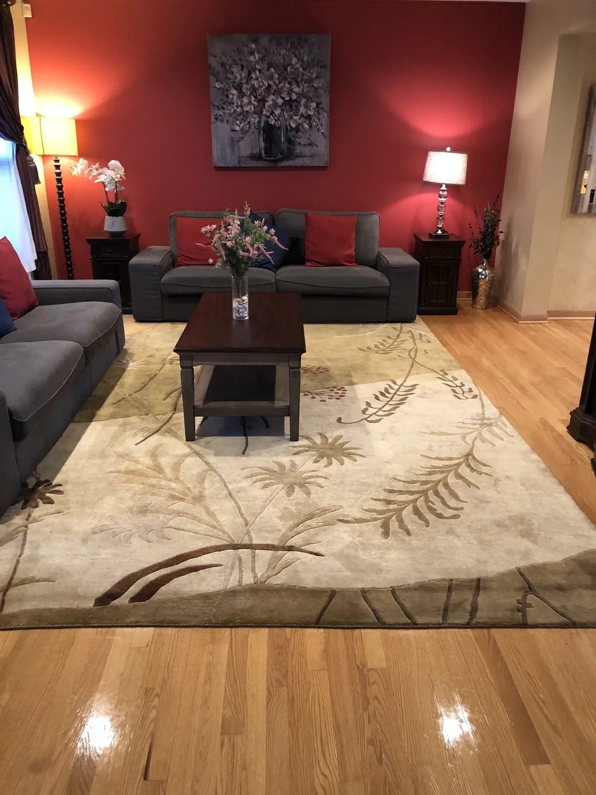 Living room with red seating, a fireplace, and a patterned rug