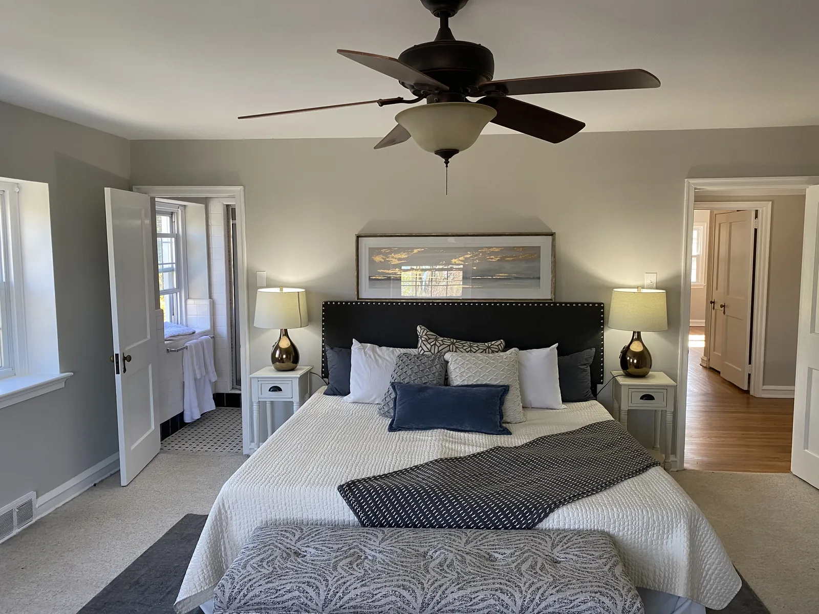 Bedroom with a made bed, wood furniture, and an area rug