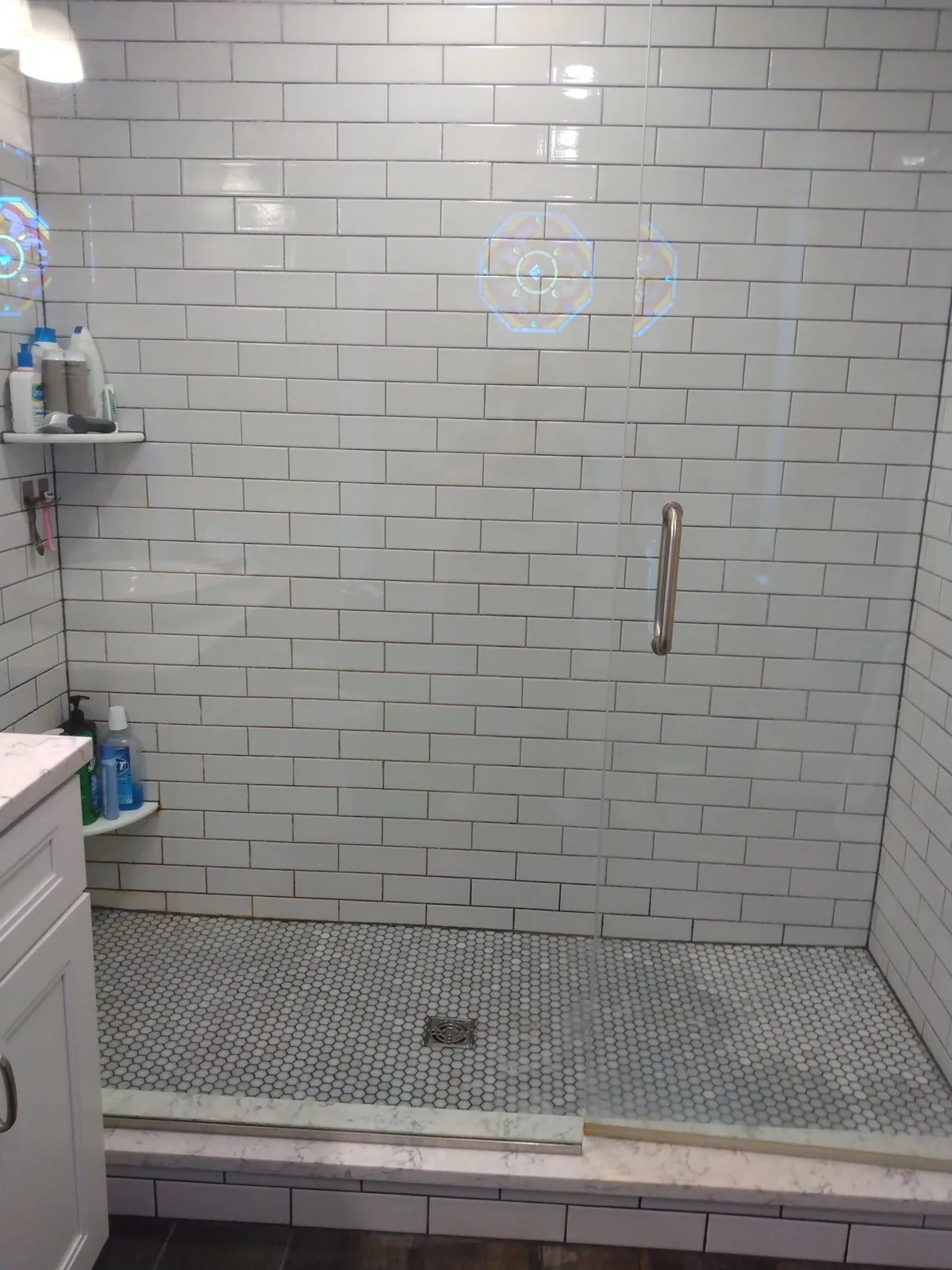Walk-in shower with white subway tile and glass doors