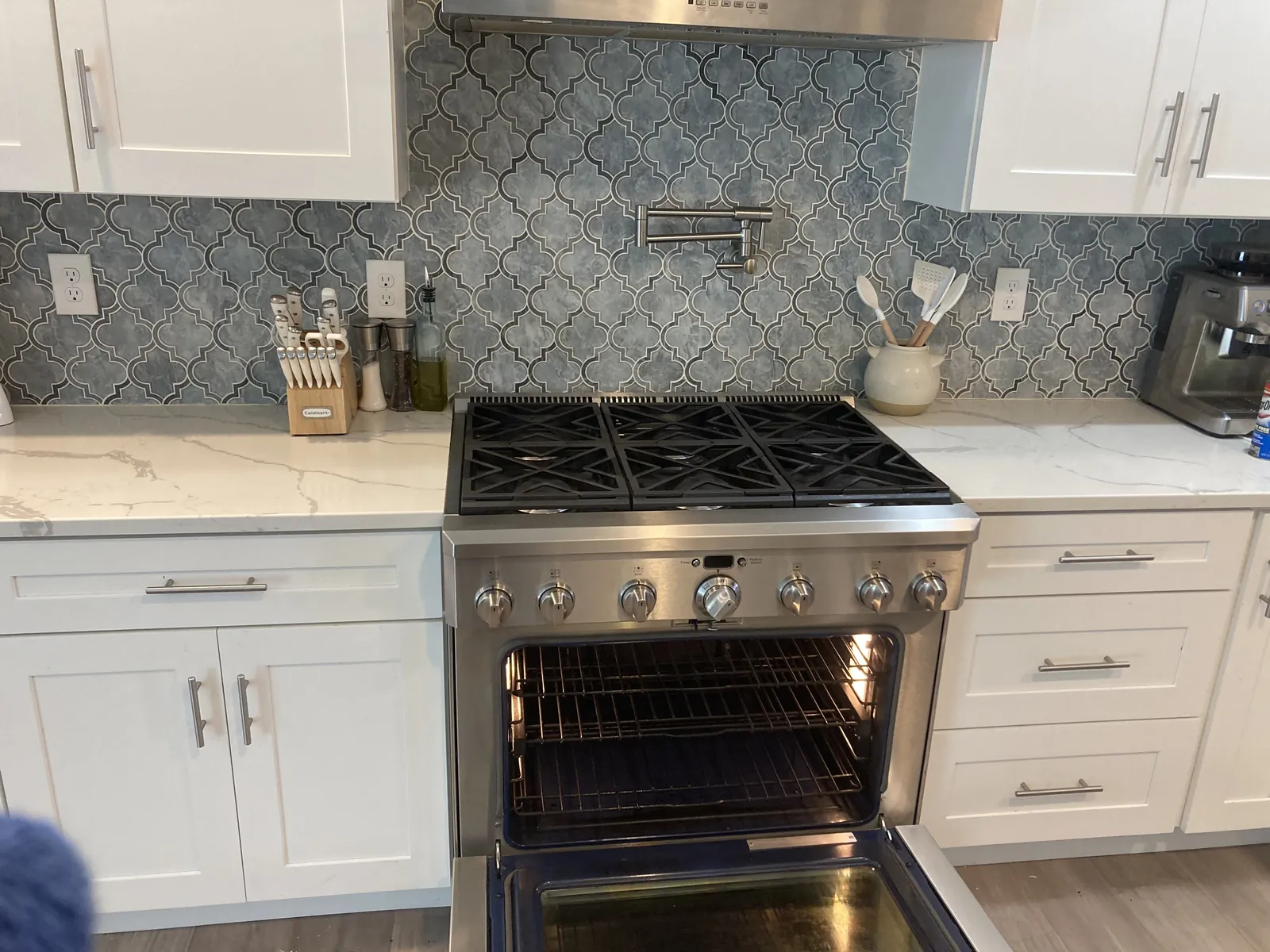 White kitchen range beneath a microwave and tiled backsplash